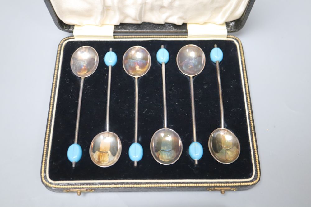 A cased set of six silver bean end coffee spoons, a silver cigarette box and two white metal dishes.